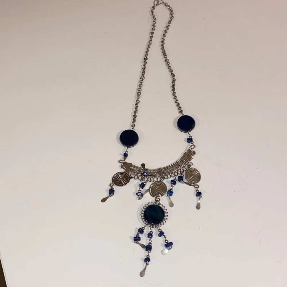Ornate Silver-Toned Necklace with a Curved Center Adorned with Blue/Black Stones